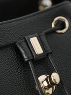 Chanel black bag clasp with gold ring, engraved metal tab, and leather strap