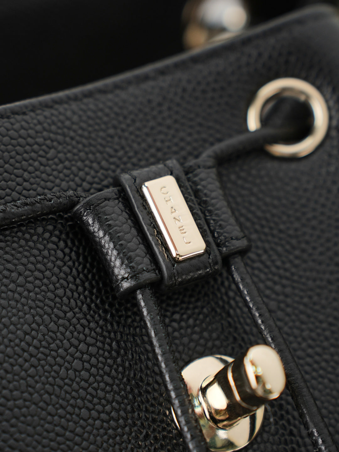 Chanel black bag clasp with gold ring, engraved metal tab, and leather strap