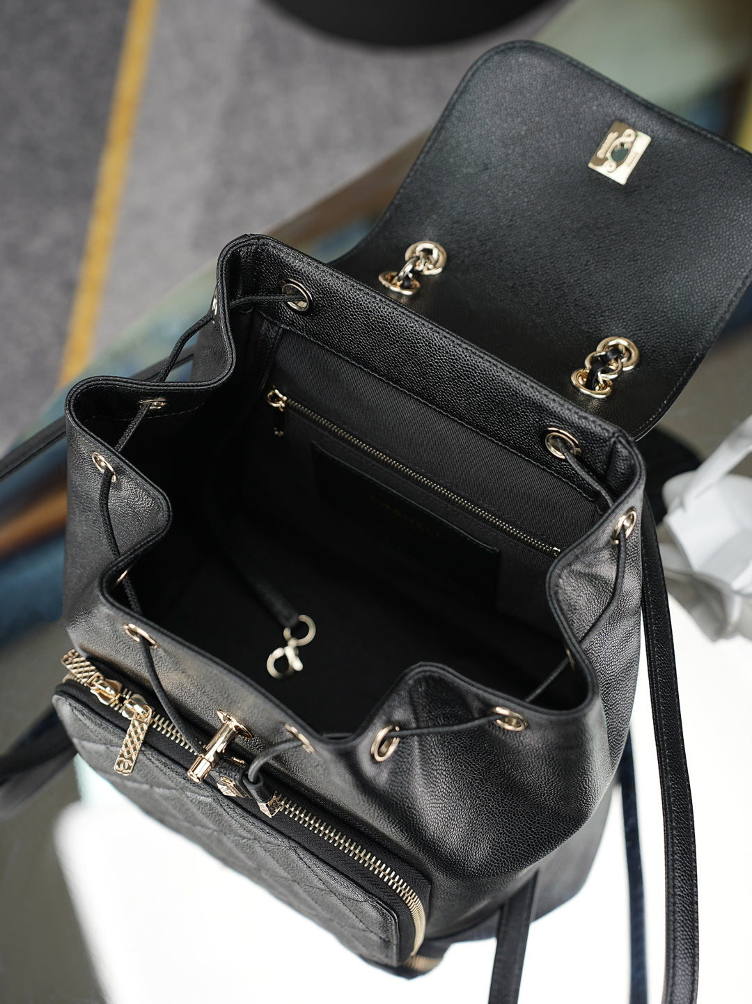 Chanel black small bag with top zip, gold hardware, and open interior