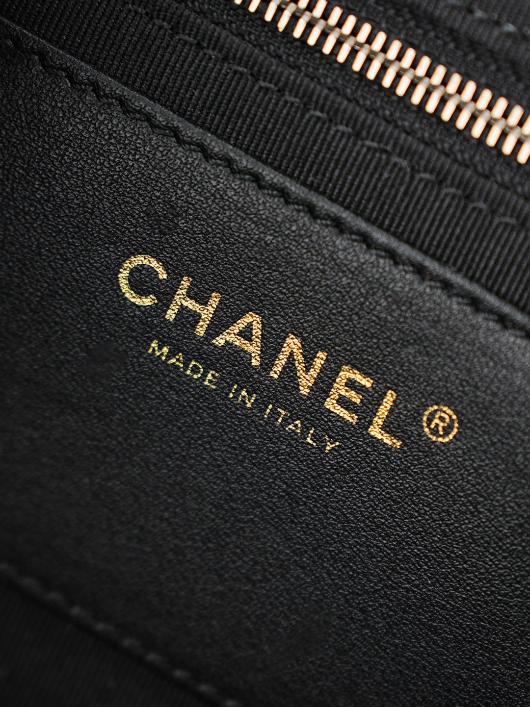 Chanel Made in Italy stamp on black leather bag edge
