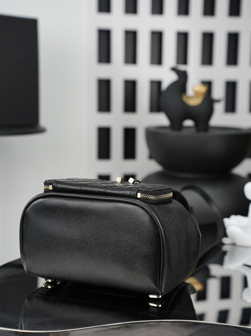 Chanel black structured bag with top zipper, gold hardware, and top handle