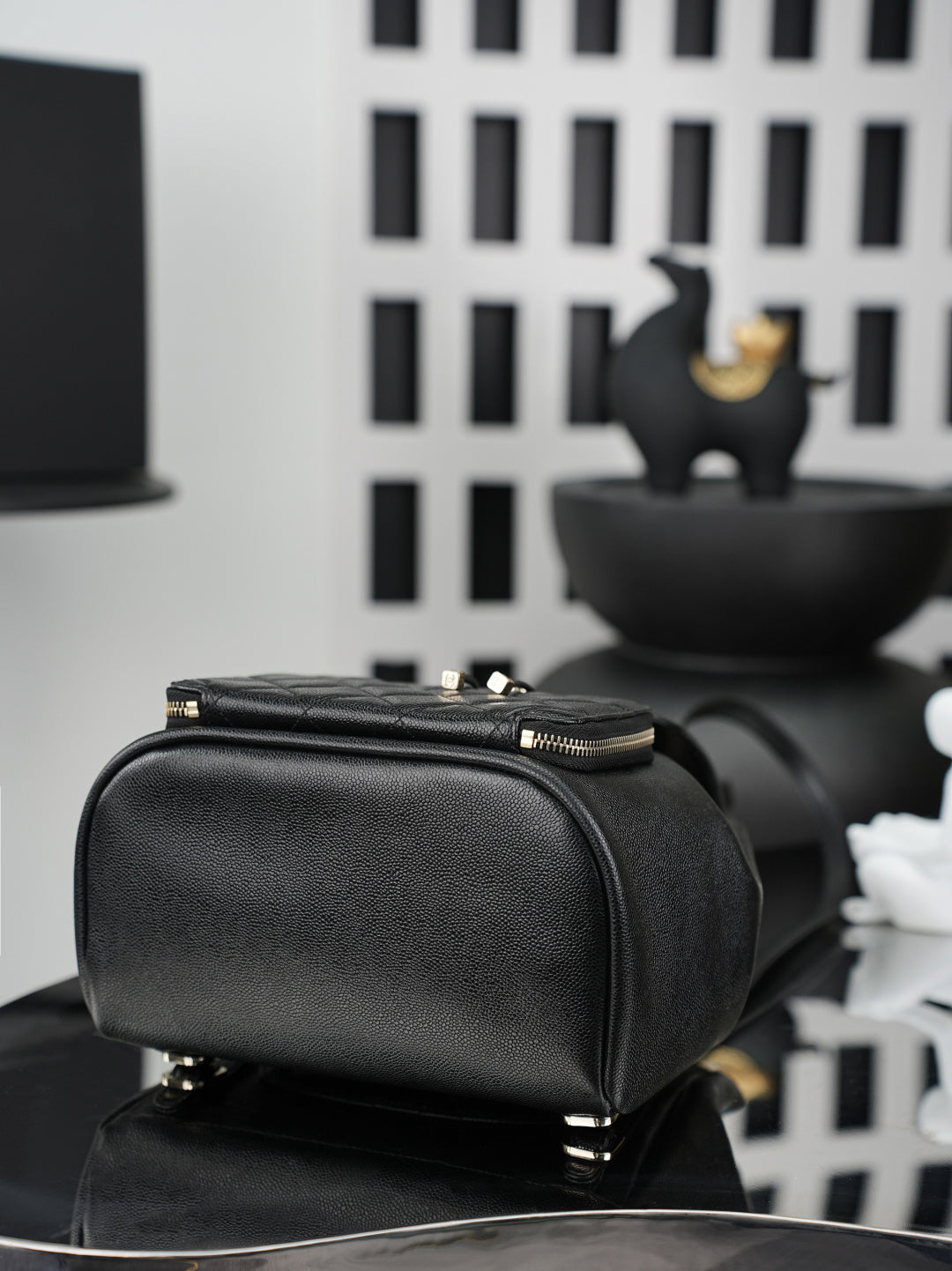 Chanel black structured bag with top zipper, gold hardware, and top handle
