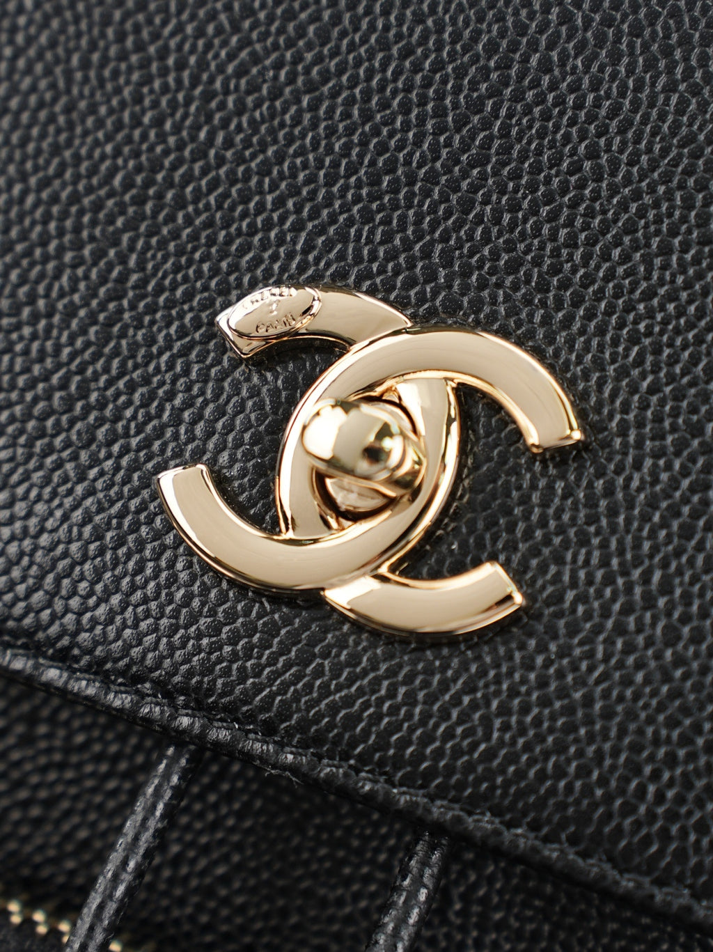 Chanel CC charm on black grained leather bag with gold-tone finish