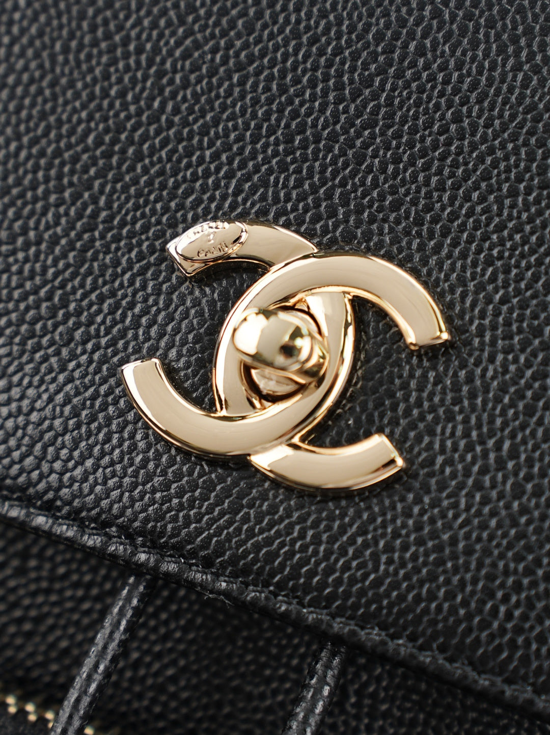 Chanel CC charm on black grained leather bag with gold-tone finish