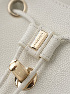 Gold-tone clasp and ring on white textured leather bag strap