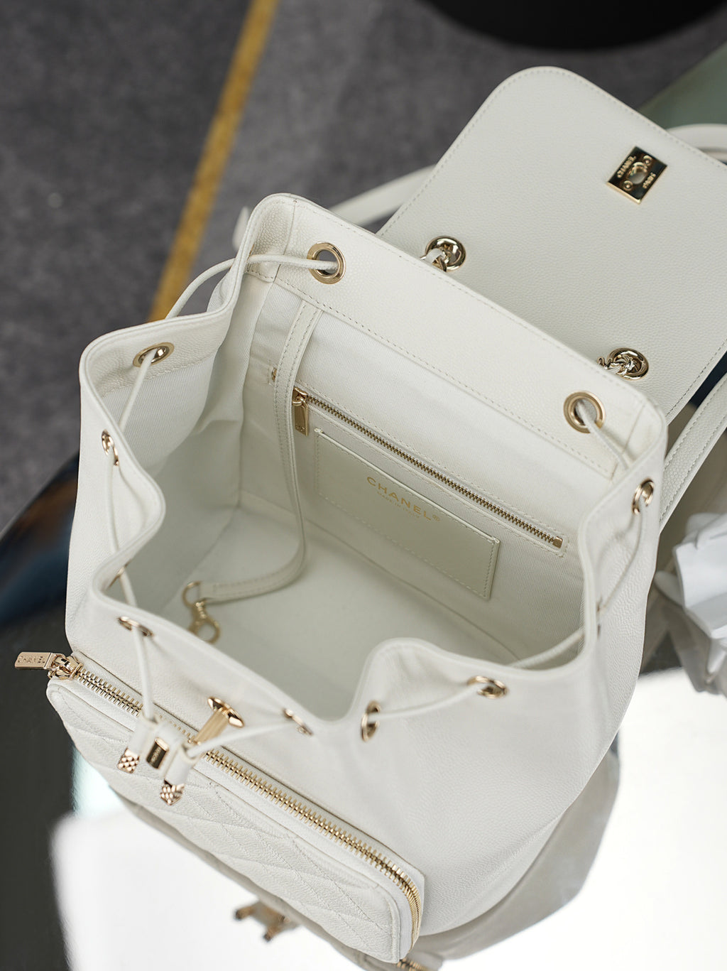 White leather shoulder bag interior view with zipper pocket and gold hardware