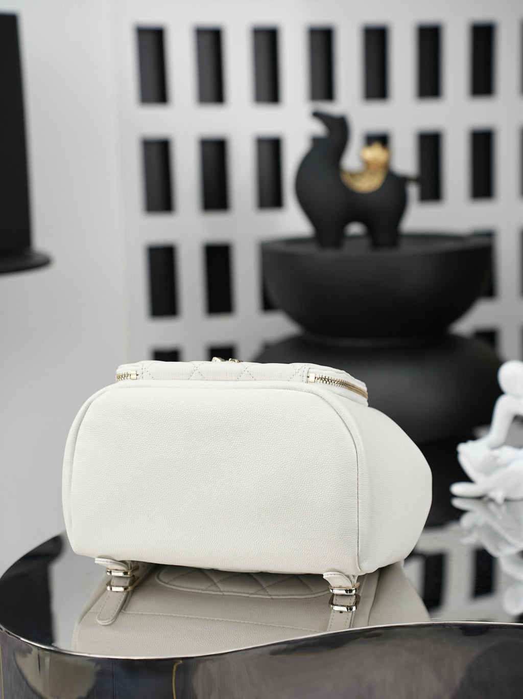 White small top-handle bag with zipper closure and textured front panel