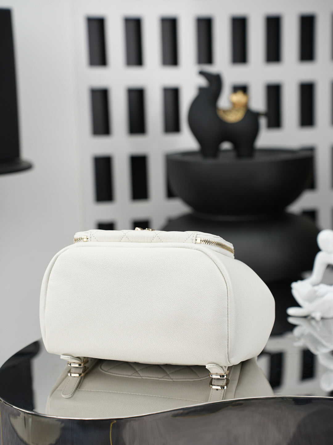 White small top-handle bag with zipper closure and textured front panel