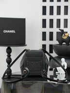 Chanel black bucket bag shown open with top handle and interior lining