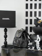 Chanel black bucket bag with chain strap, drawstring top, and front pockets