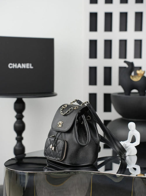 Chanel black bucket bag with chain strap, drawstring top, and front pockets