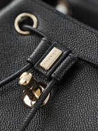Chanel hardware close-up on black textured leather bag strap