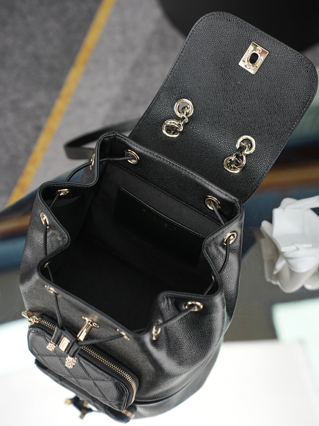 Chanel black mini bucket bag open view with front zipper pocket and hardware