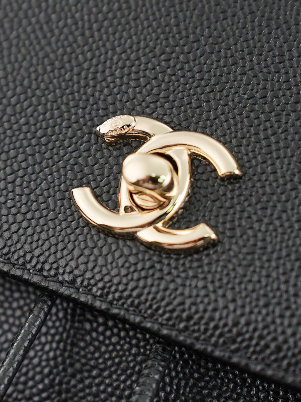 Chanel gold-tone CC charm on textured black leather bag