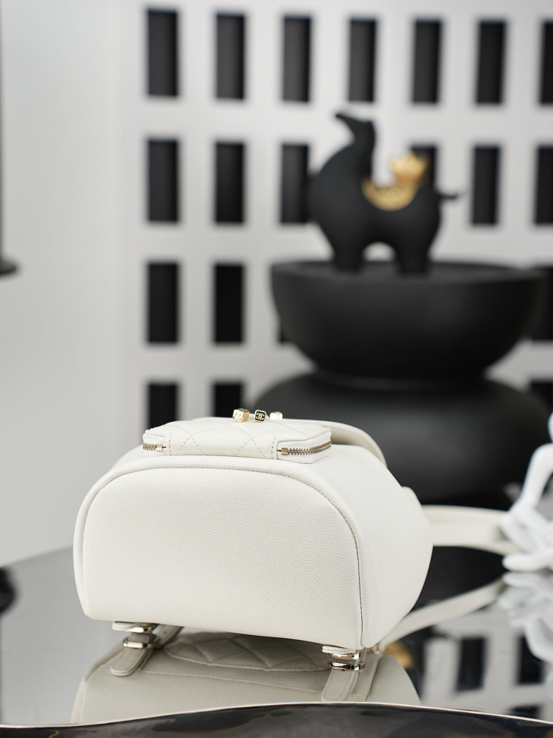 White bucket bag with chain strap and gold-tone hardware, side view