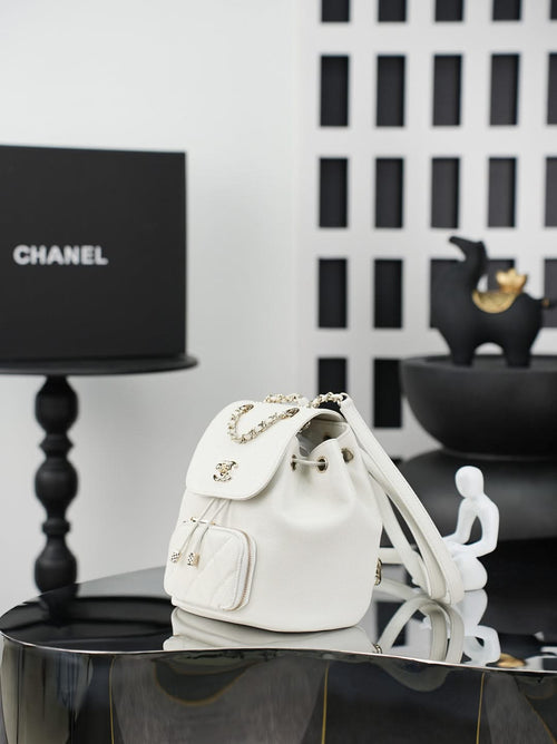 White quilted bucket bag with gold chain handle and drawstring opening, front pocket