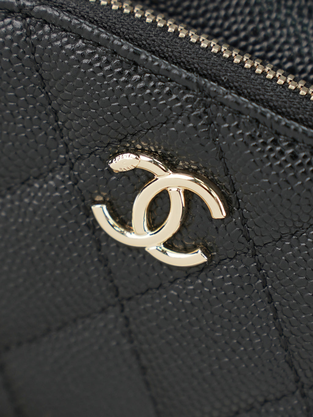 Chanel CC logo on dark textured leather with gold-tone emblem