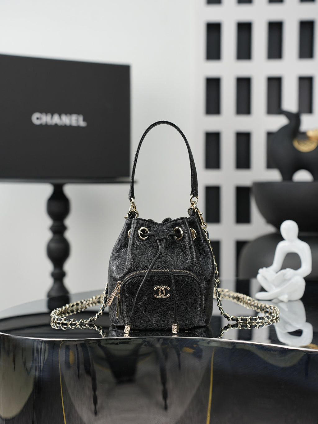 Chanel drawstring bag in dark leather with gold chain strap and CC logo front
