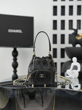 Chanel drawstring bag in dark leather with gold chain strap and CC logo front