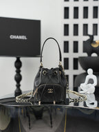 Chanel drawstring bag in dark leather with gold chain strap and CC logo front