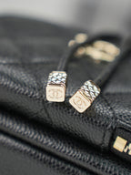 Chanel logo zipper pulls on dark leather with gold-tone hardware