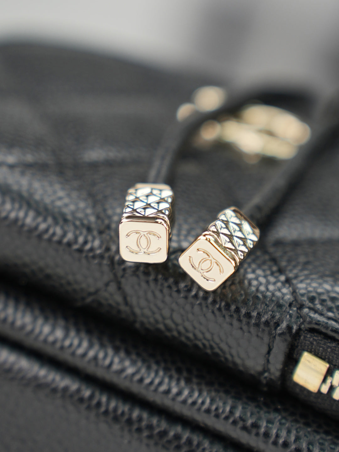 Chanel logo zipper pulls on dark leather with gold-tone hardware