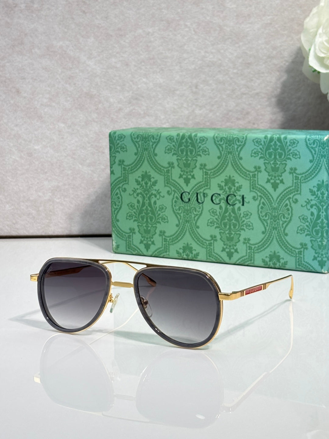 Gucci sunglasses with gold-tone frame, dark tinted lenses and round corners