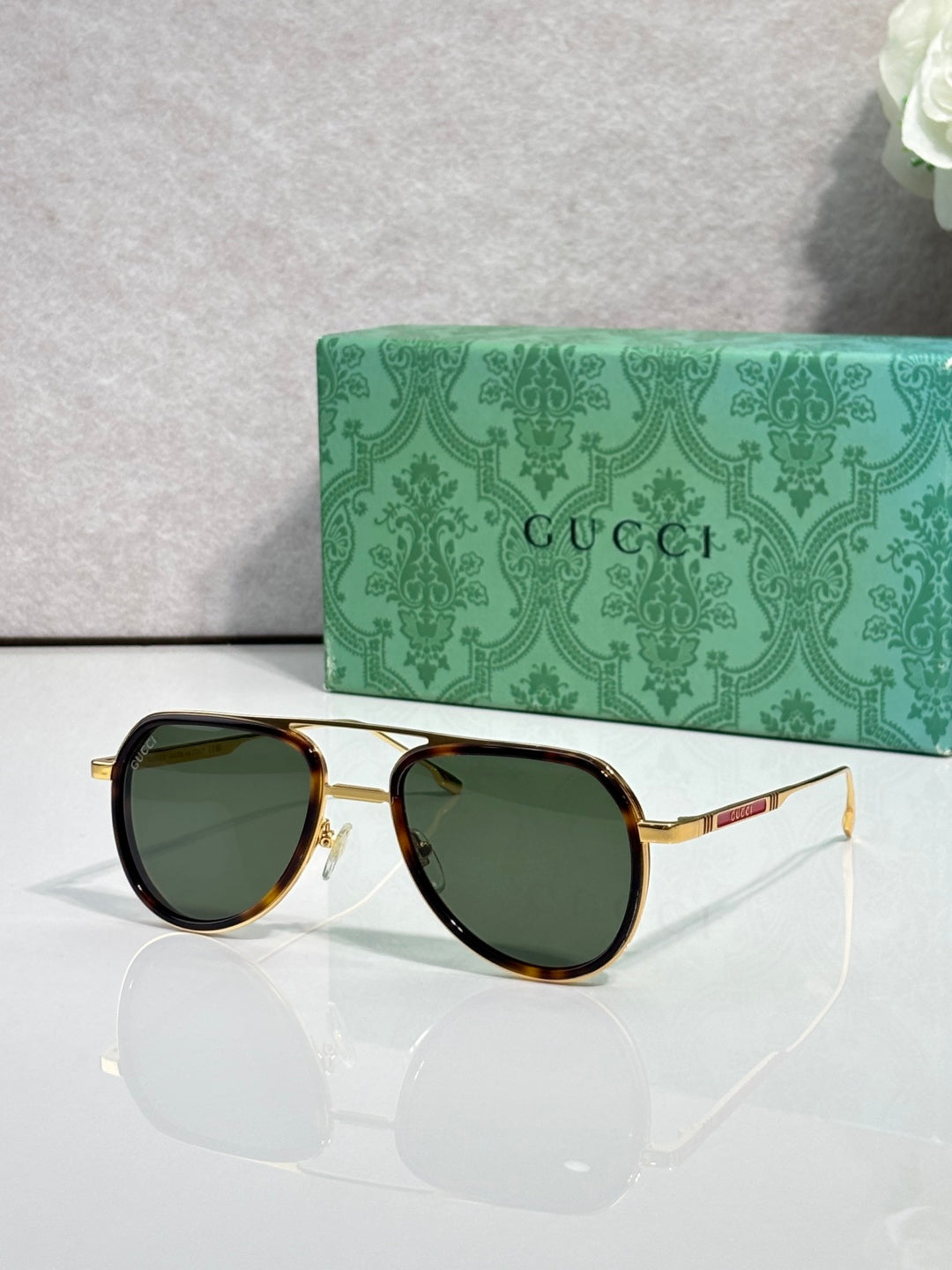 Gucci sunglasses with gold-tone frame and green-tinted lenses, side angle