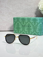 Gucci sunglasses with black frame and dark tinted lenses, gold-tone temples