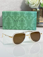 Gucci sunglasses with gold-tone frame and brown-tinted lenses, top-down angle