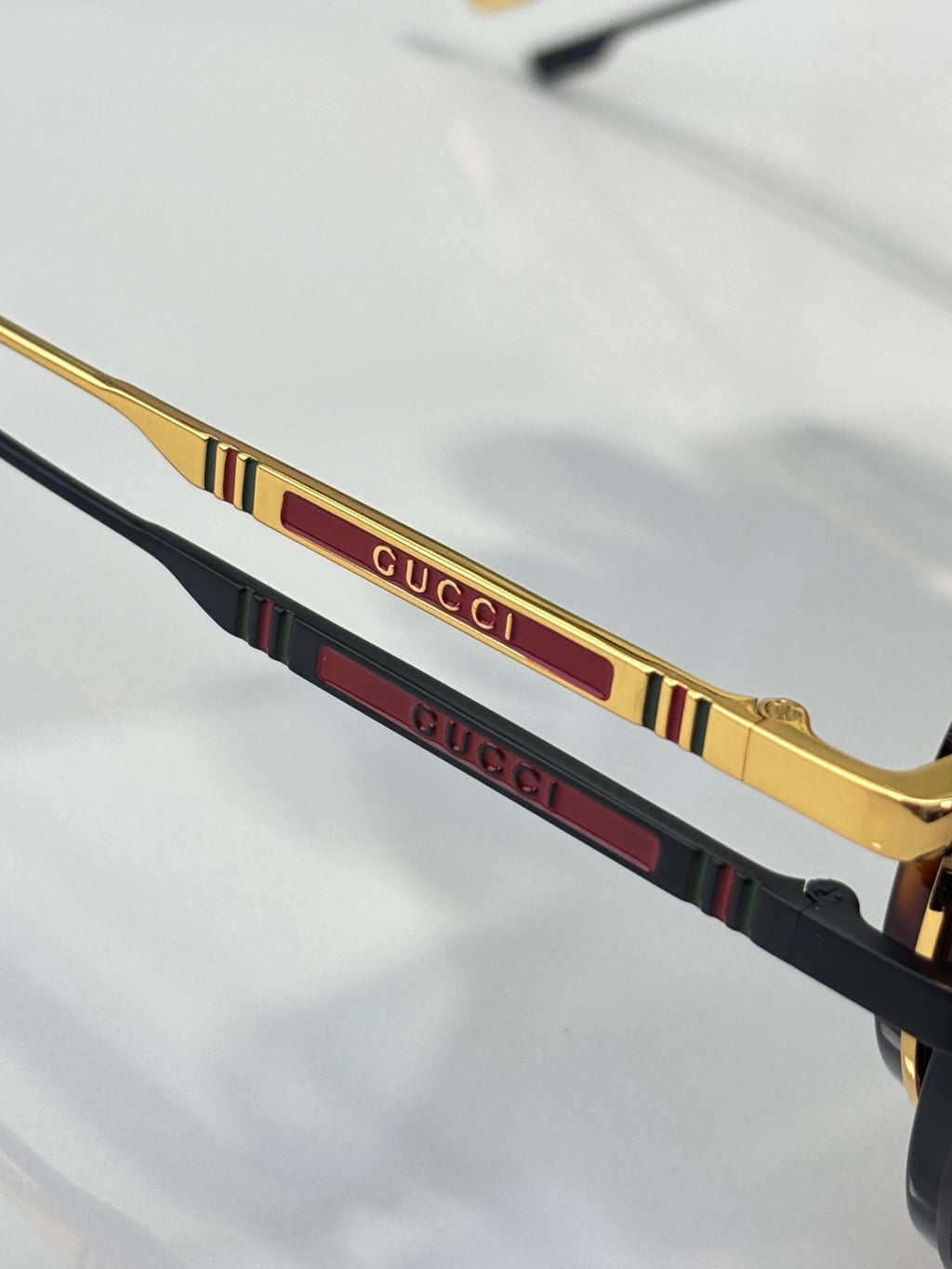 Gucci sunglasses temple detail with gold trim and multicolor stripe