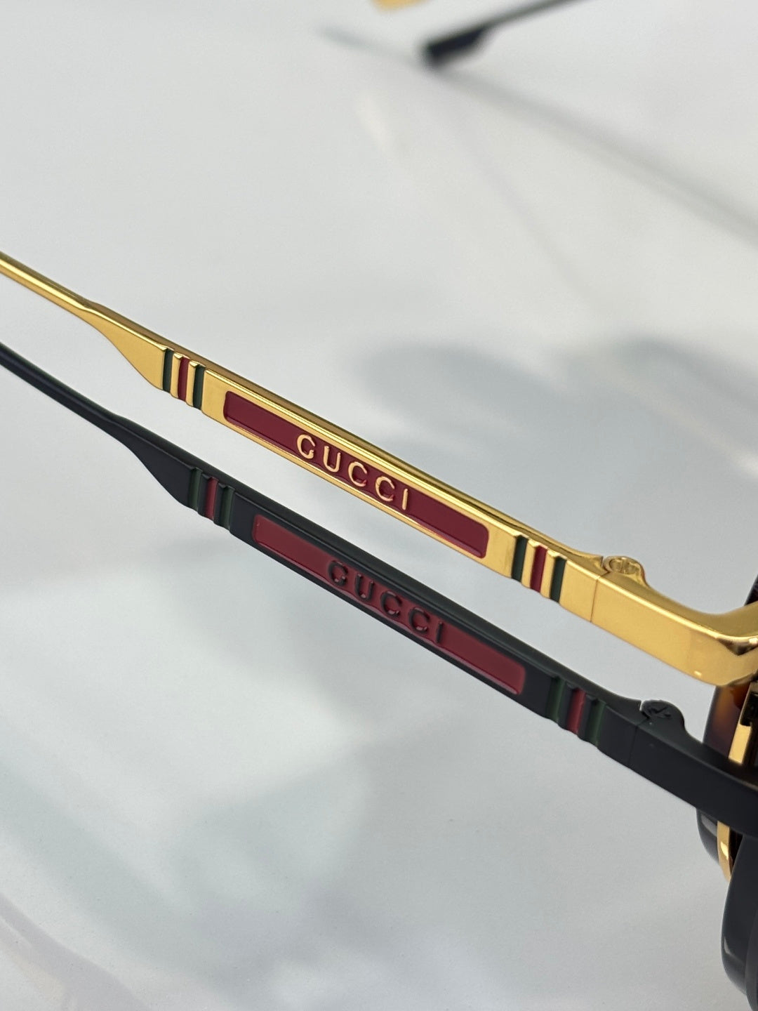 Gucci sunglasses temple detail with gold trim and multicolor stripe