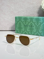 Gucci sunglasses with gold-tone frame and brown-tinted lenses, front view