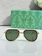 Gucci sunglasses, cat-style with green lenses and gold frame with tortoiseshell trim
