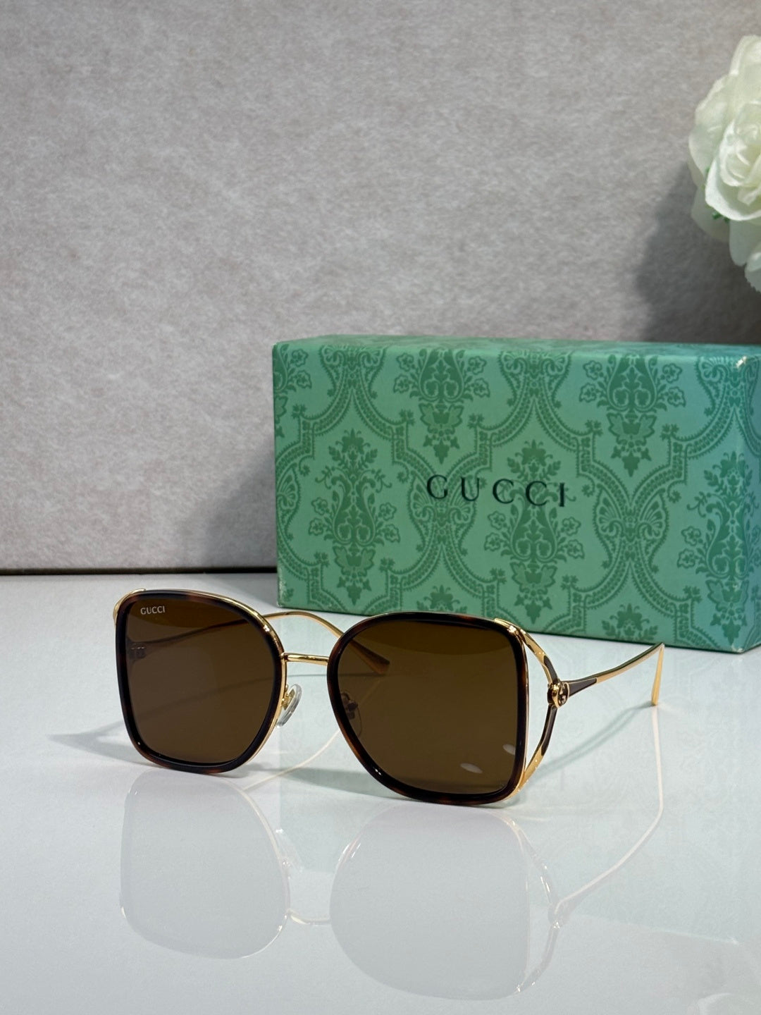 Brown metal sunglasses with dark brown tinted lenses and square rounded frames