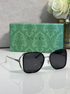 Black sunglasses with glossy frames and dark tinted lenses, square rounded shape