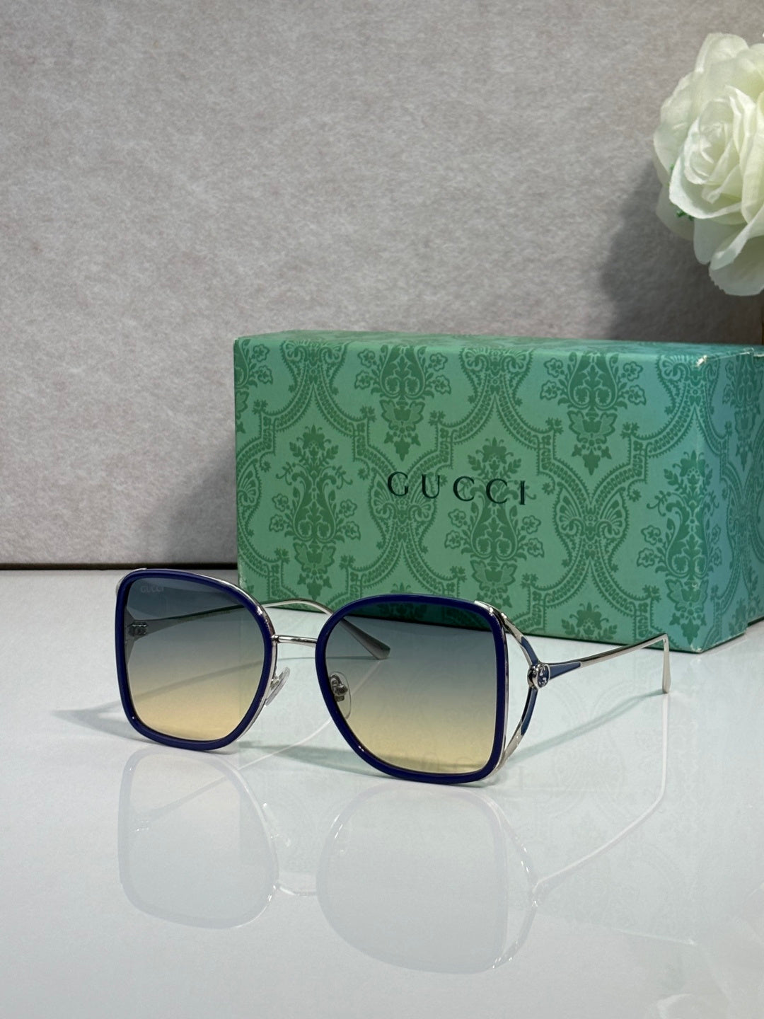 Blue metal sunglasses with dark tinted lenses and square rounded frames