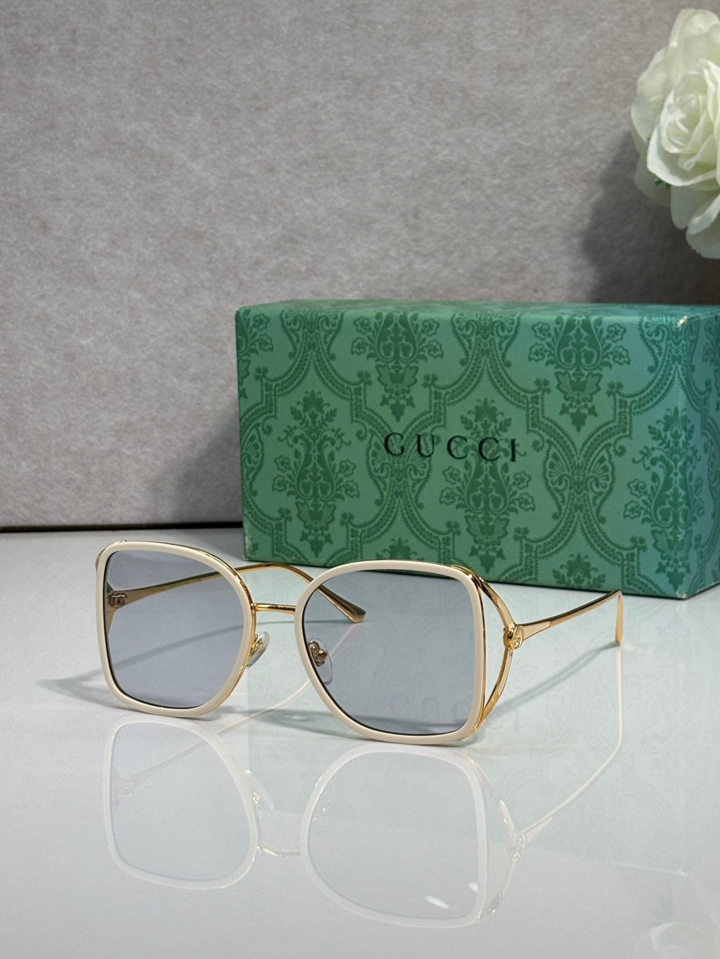 Gold metal sunglasses with light tinted lenses and square rounded frames
