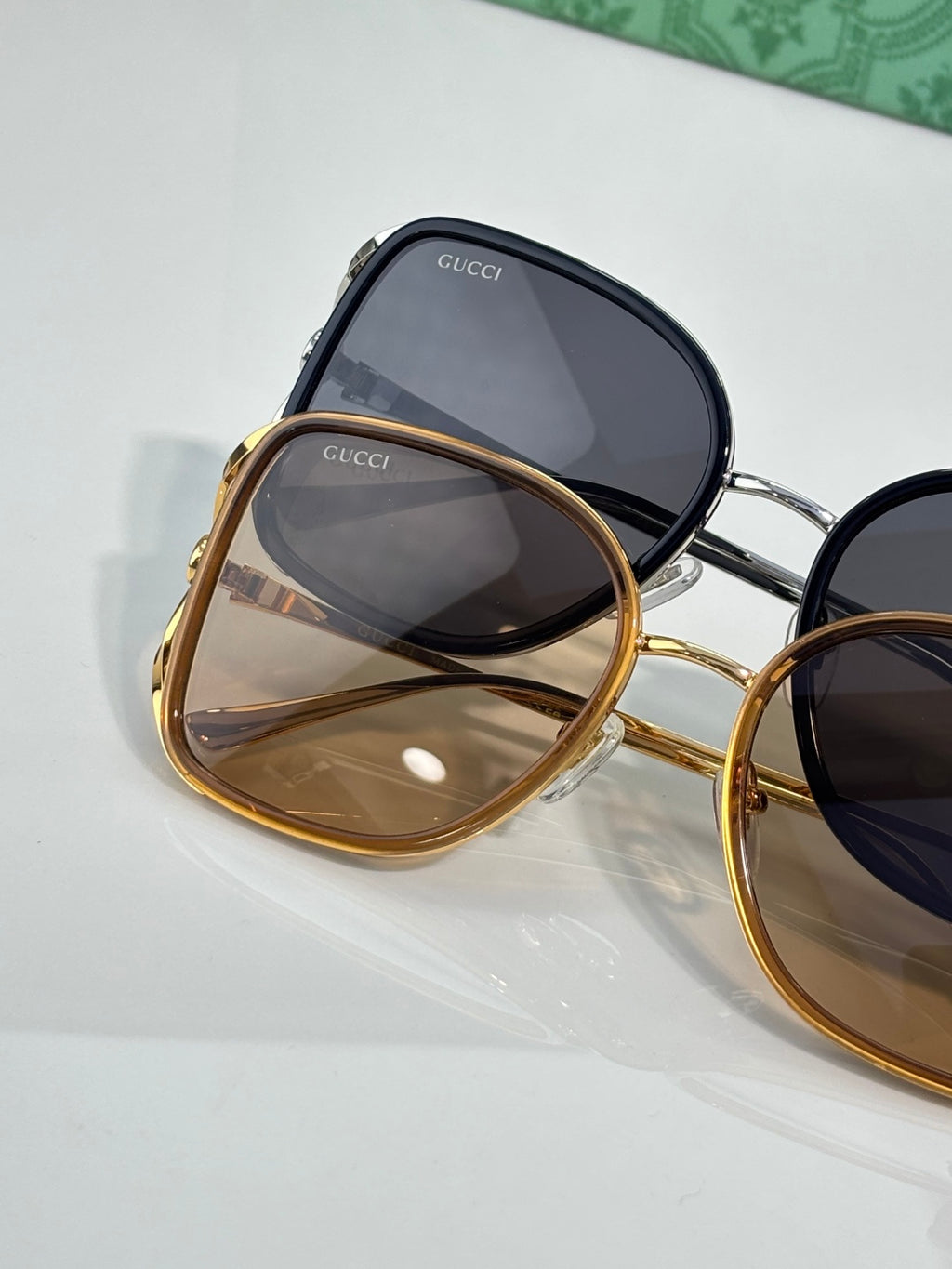 Sunglasses with stacked dark and gold frames, dark and amber tinted lenses close-up