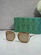 Gold and dark brown metal sunglasses with light tinted lenses and square rounded frames