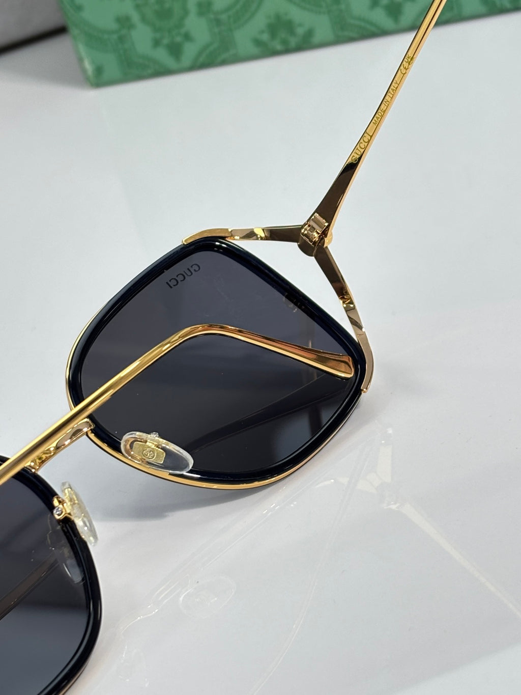 Gold-tone sunglasses with dark lenses and detailed temple hardware