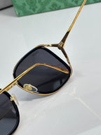 Gold-tone sunglasses with dark lenses and detailed temple hardware