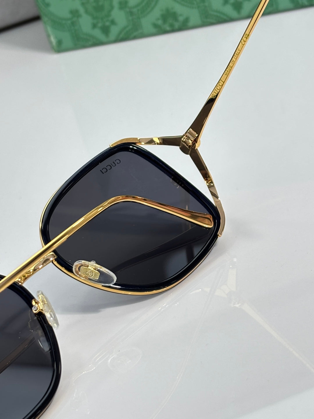Gold-tone sunglasses with dark lenses and detailed temple hardware