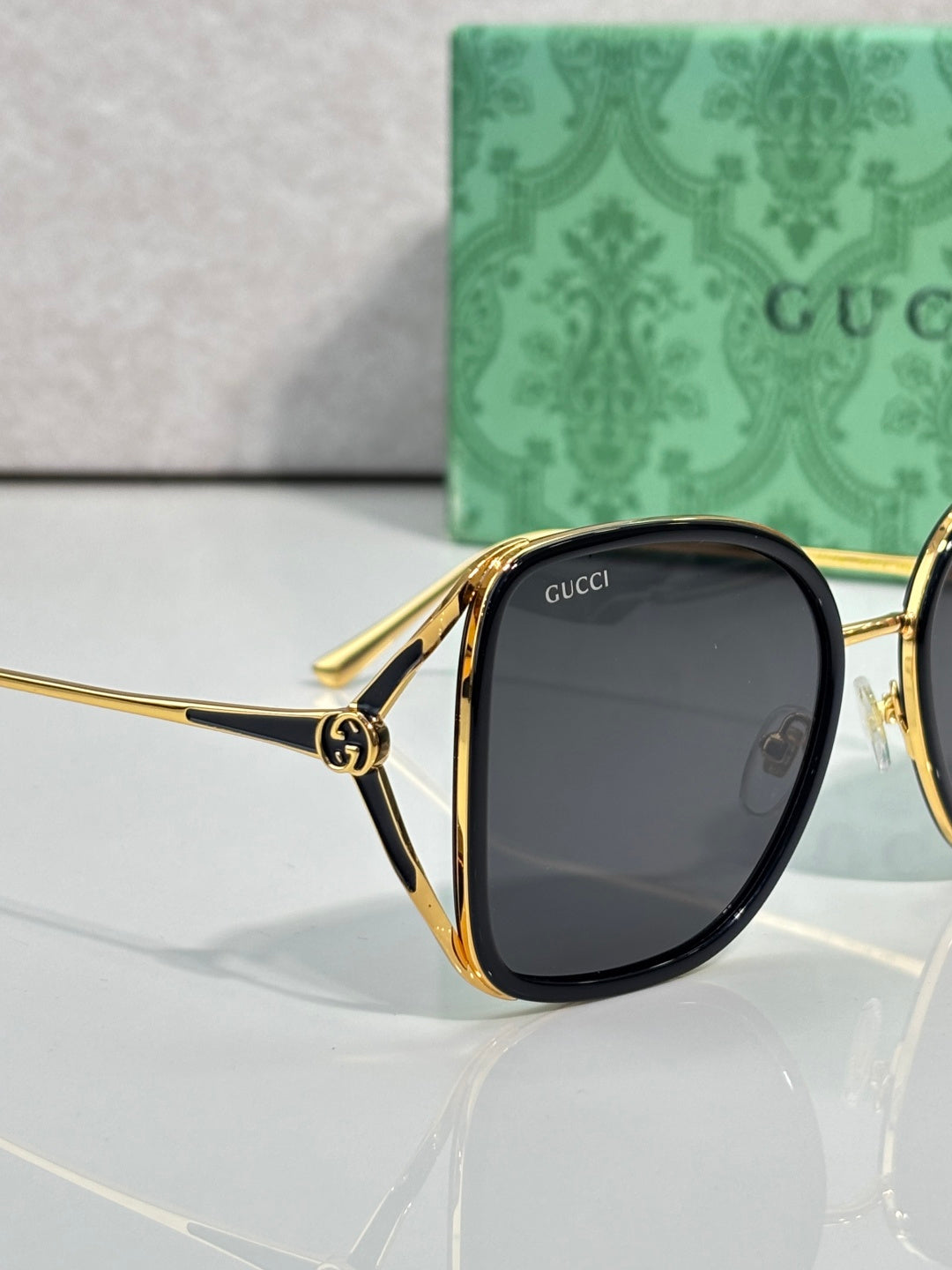 Gold-tone sunglasses with dark oval lenses and curved metal arms