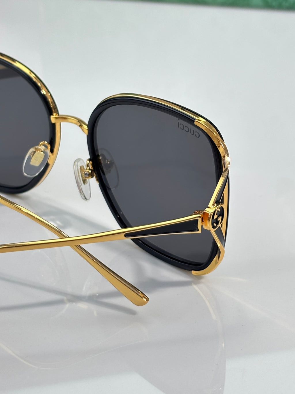 Dark square sunglasses with gold-tone rim and temple with logo