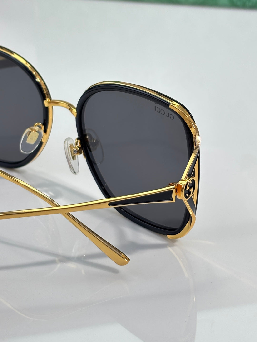 Dark square sunglasses with gold-tone rim and temple with logo