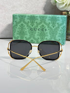 Square sunglasses with gold-tone frames and dark lenses, front view