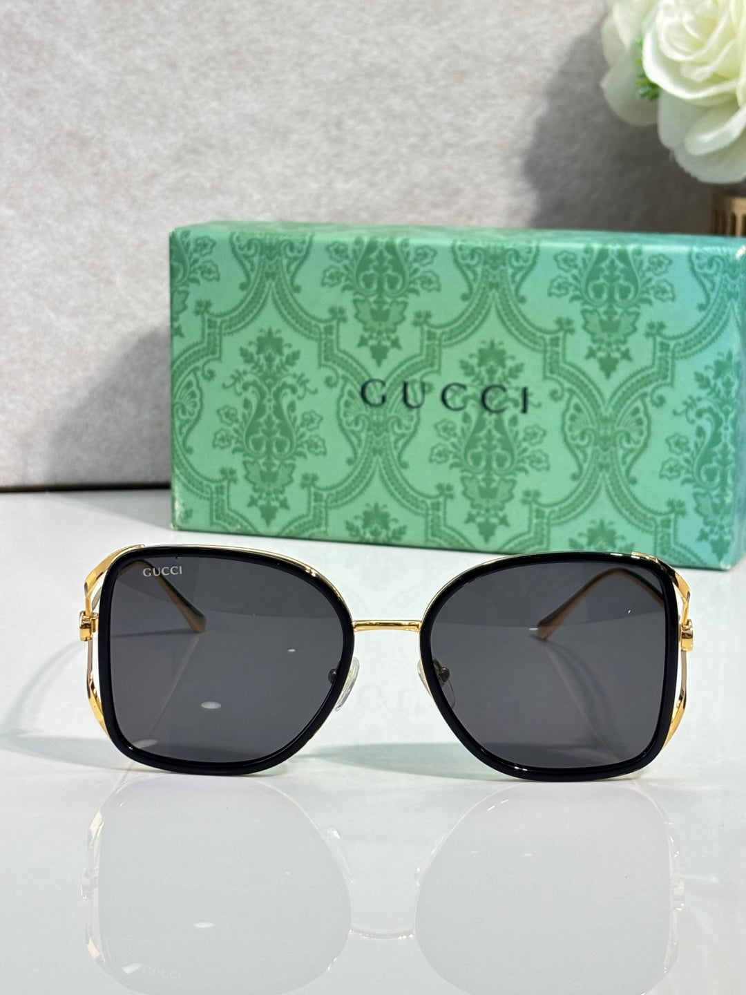 Square sunglasses with gold-tone frames and dark tinted lenses