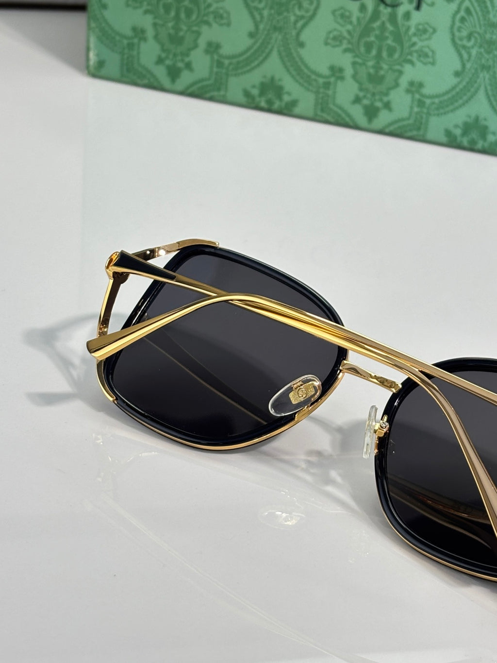 Sunglasses with gold-tone metal arms and dark tinted lenses, angled