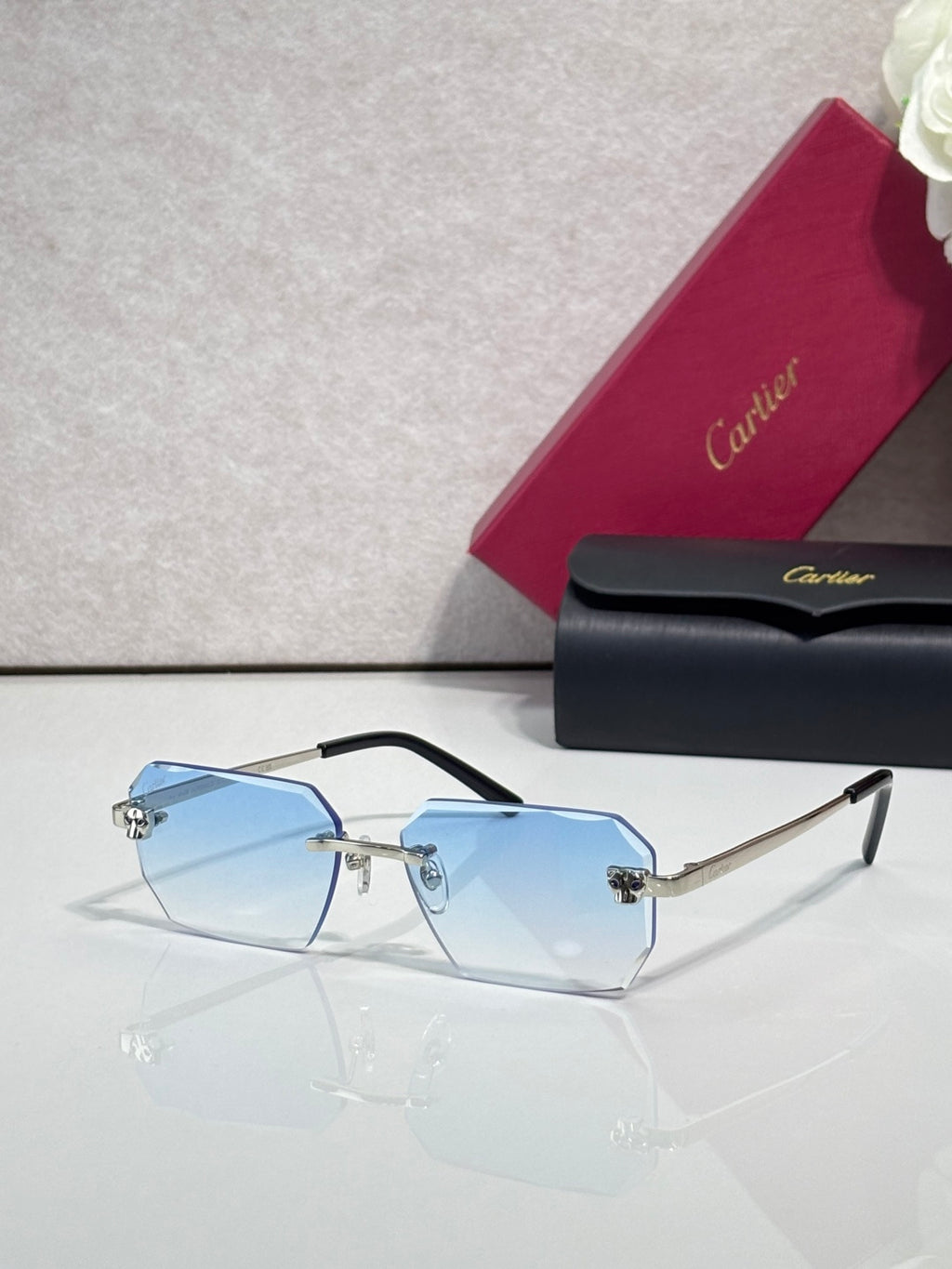 Cartier rectangular eyeglasses with black temples, blue-tinted lenses, gold hardware